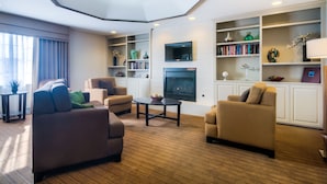 A modern living room with sofas, a coffee table, and a fireplace. - Sleep Inn Midway Airport Bedford Park (Chicago)