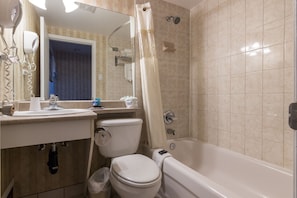 Une salle de bain comprenant des toilettes, un lavabo et une baignoire.