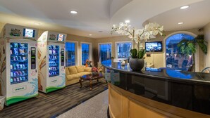 A lobby with vending machines, a sofa, a coffee table, and a reception desk.