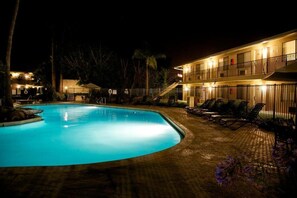 Alberca techada, alberca al aire libre y sombrillas en la alberca