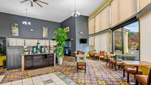 A modern hotel lobby with a large window, a reception desk, and a patterned carpet. - Quality Inn Hillsville (Hillsville)