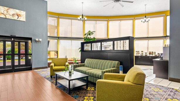 A spacious living area with a sofa, armchairs, a coffee table, and a bookshelf. - Quality Inn Hillsville (Hillsville)