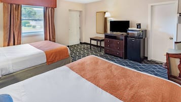 Habitación de hotel con dos camas, televisión, cafetera y cómoda.