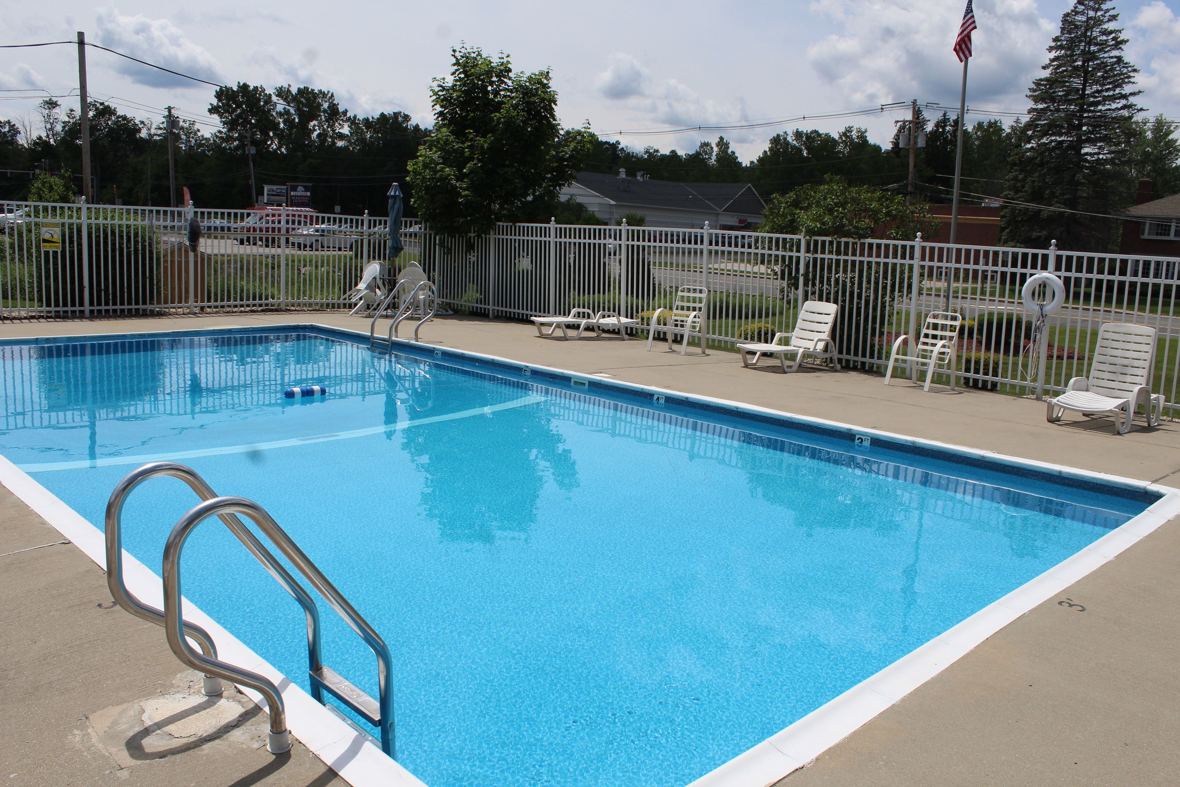 Une piscine rectangulaire avec une échelle métallique située sur le côté gauche.