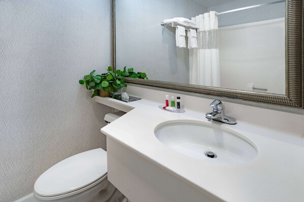 A bathroom with a white sink, mirror, and toilet. - Howard Johnson by Wyndham Lenox (Lenox)
