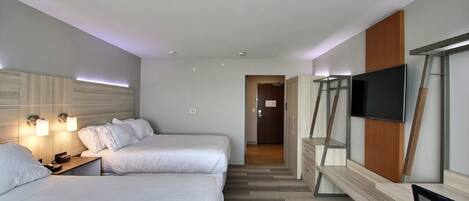Ett hotellrum med två sängar, ett skrivbord, en TV och en garderob.