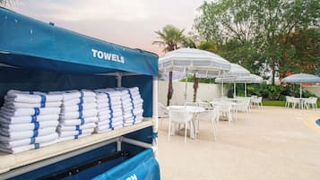 Una piscina al aire libre de temporada, sombrillas