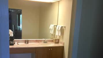 A bathroom with a sink, mirror, and towel rack.