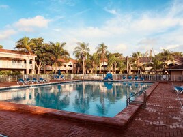 Una piscina al aire libre, sillones reclinables de piscina