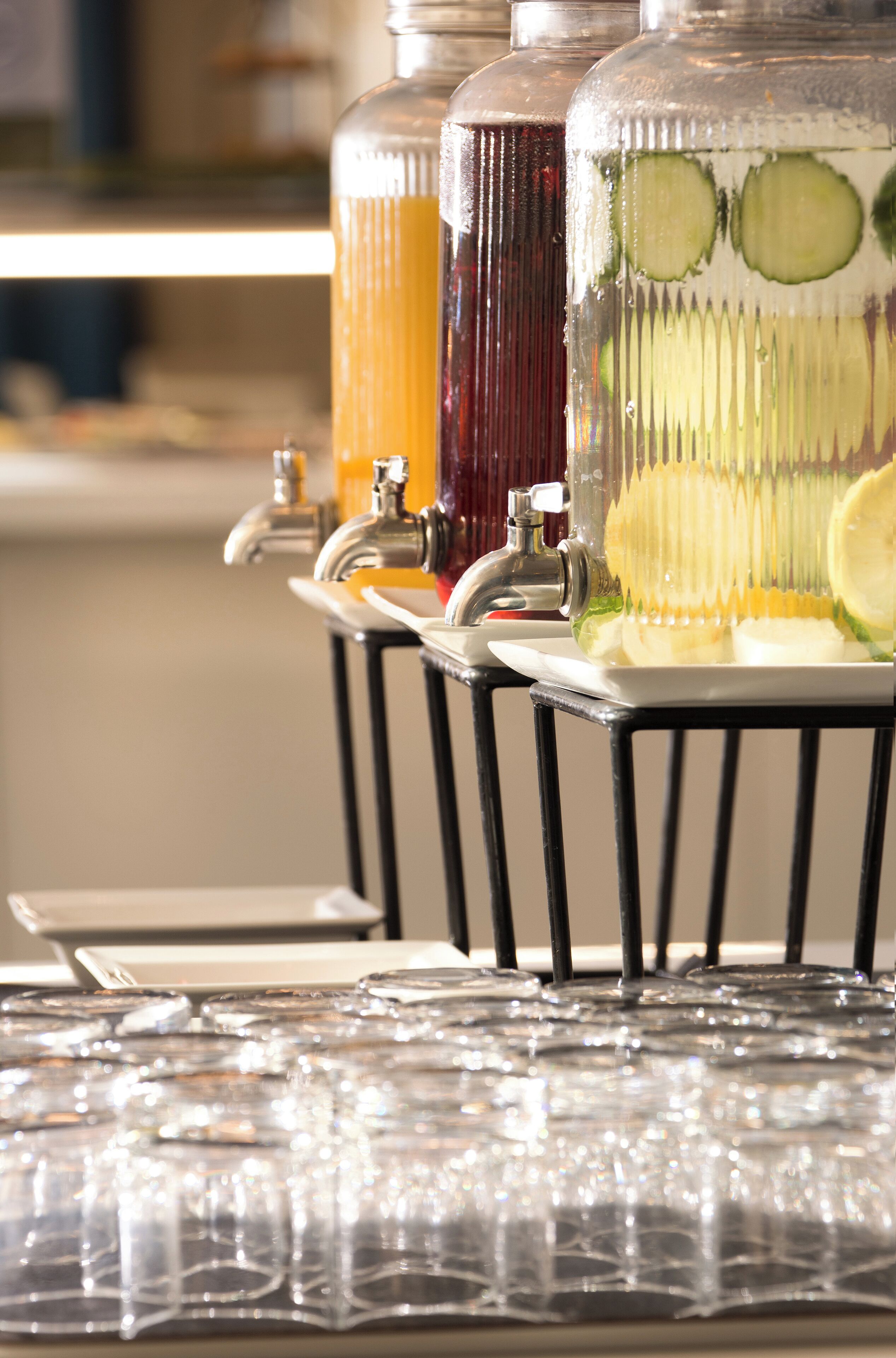 Un distributeur de boissons proposant plusieurs types de boissons et muni d’une rangée de verres en dessous.