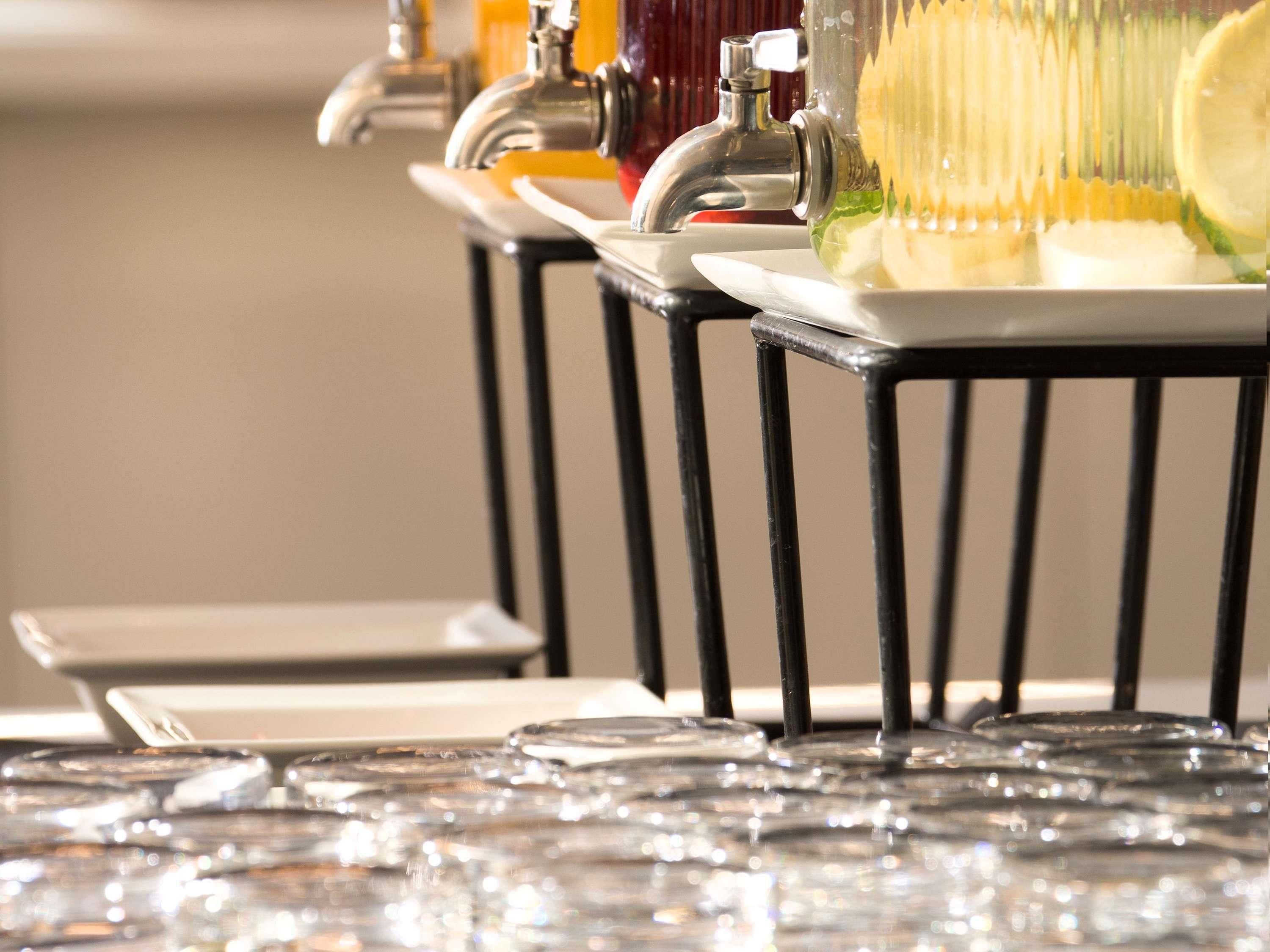 A bar area with multiple taps, glasses, and a bar counter.