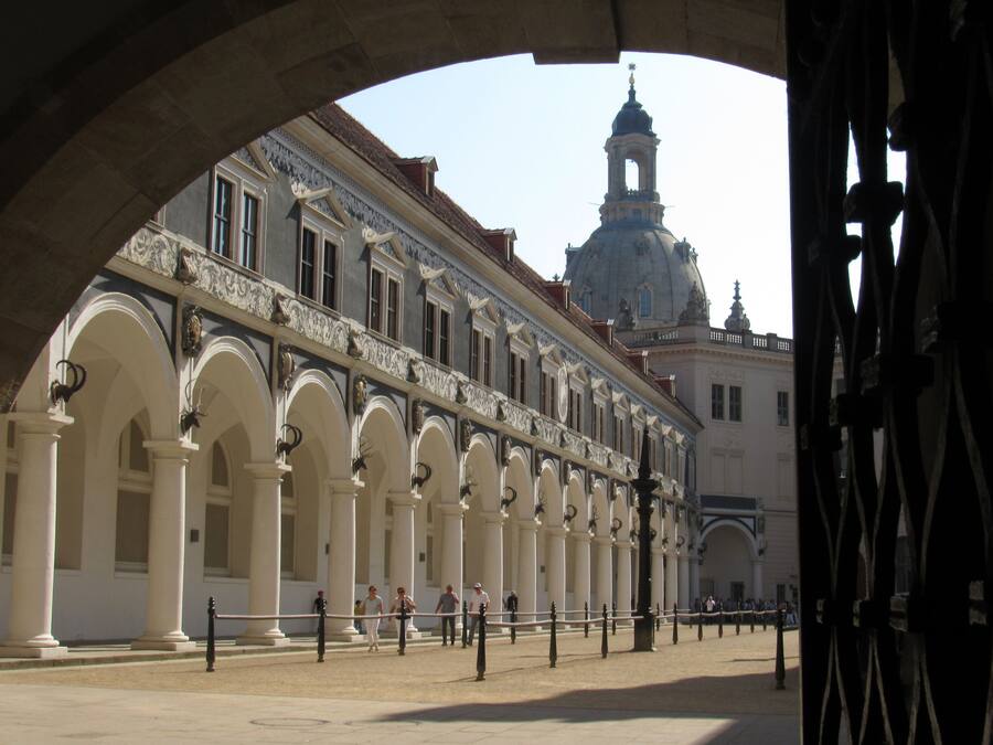 A historic building with a central dome and arched colonnades.