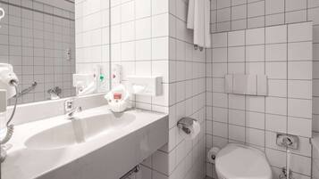 Ein Badezimmer mit Waschbecken, Spiegel und Toilette.