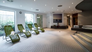 A spa room with green massage chairs, a reception desk, and a large window with a view of greenery. - Ramada by Wyndham Dresden (Dresden)