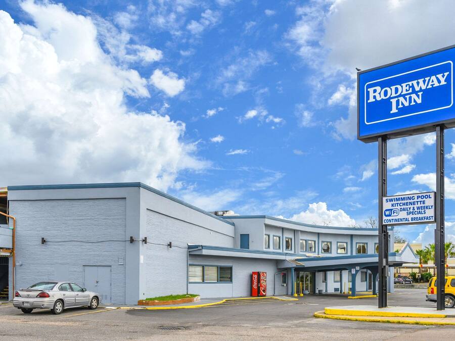 A Rodeway Inn with a signboard advertising amenities like a swimming pool, kitchenette, Wi-Fi, daily breakfast, and continental breakfast.