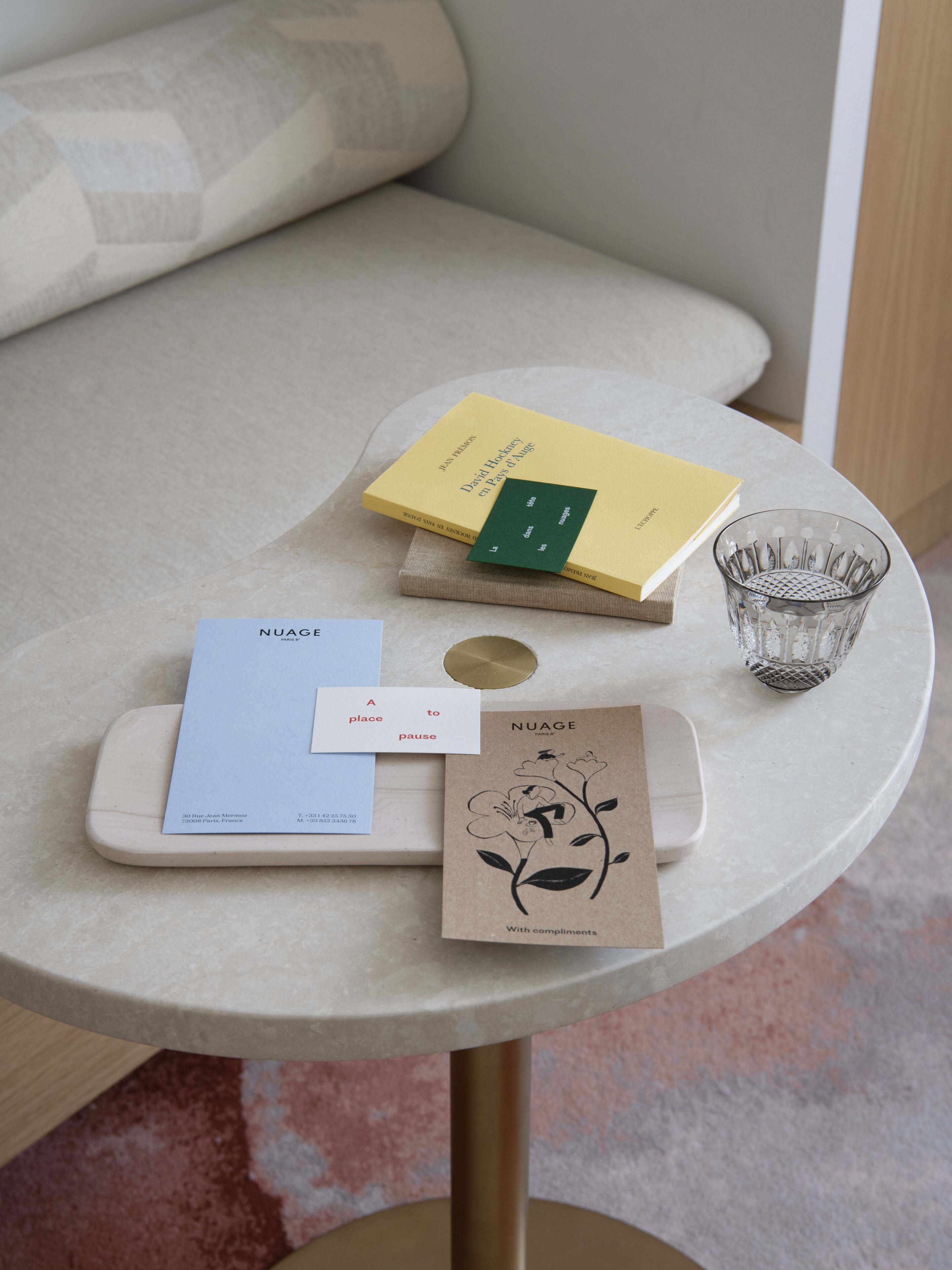 Ein Tisch mit einem Buch, einer Karte, einem Glas und einer kleinen Pflanze.