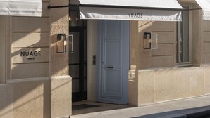A building facade with a storefront labeled "NUAGE" and a white awning. - Nuage Hôtel (Paris)