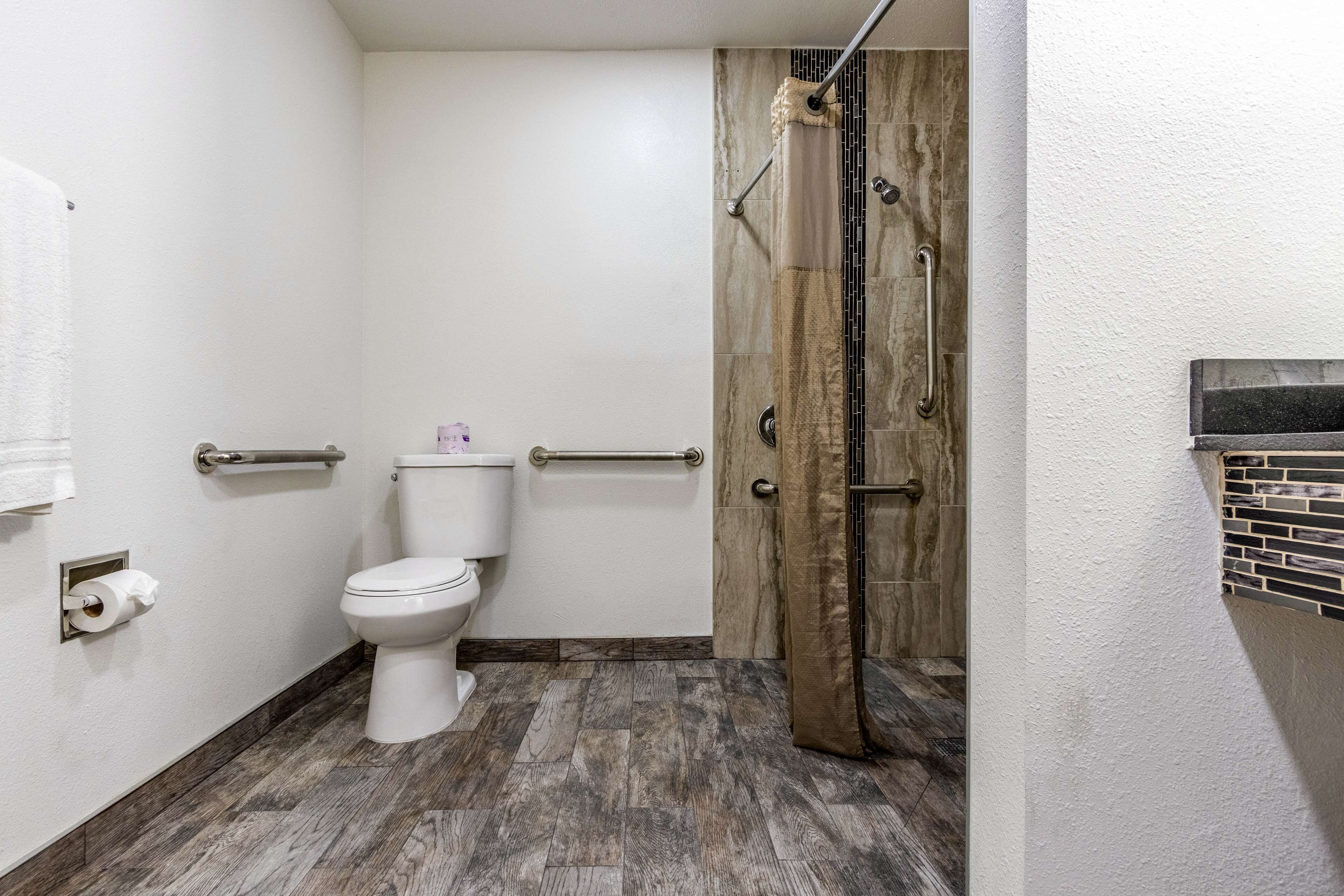 A bathroom with a toilet, a shower with a glass door, and a towel rack.