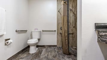 A bathroom with a toilet, a shower with a glass door, and a towel rack.
