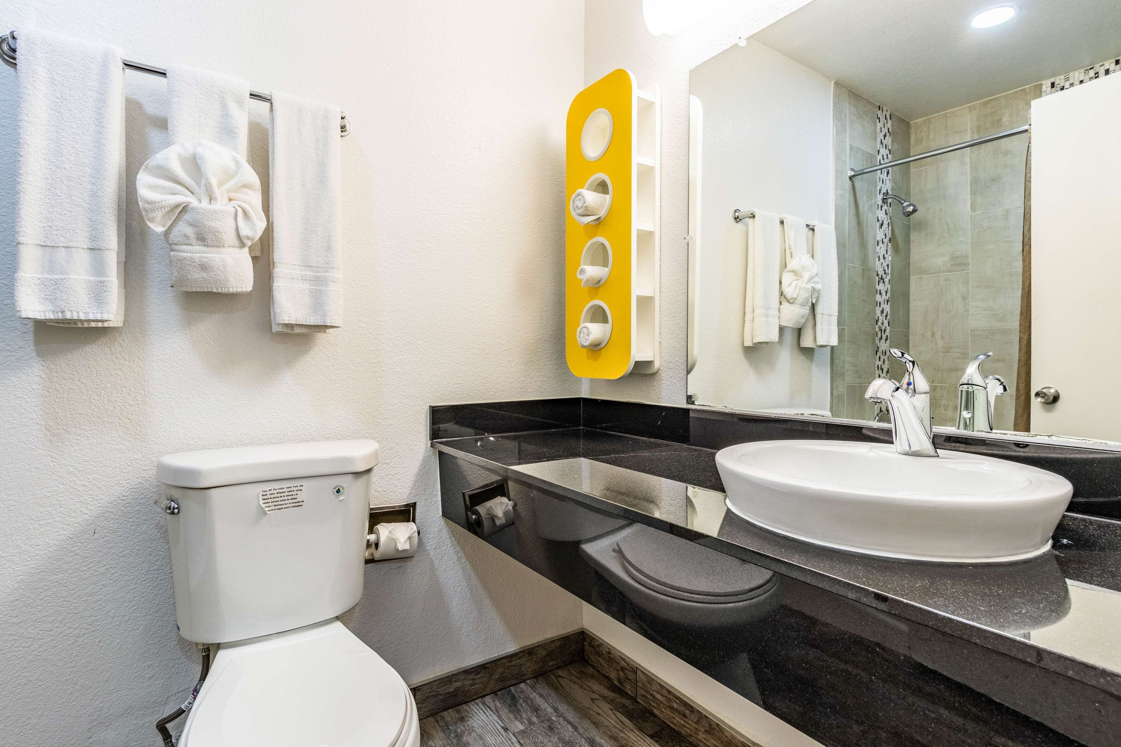 A modern bathroom with a toilet, sink, and shower.