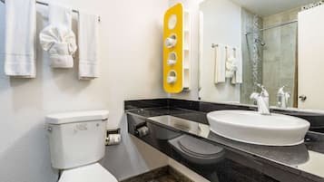 A modern bathroom with a toilet, sink, and shower.