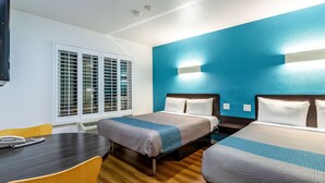 Una habitación de hotel con dos camas, un escritorio y una silla.