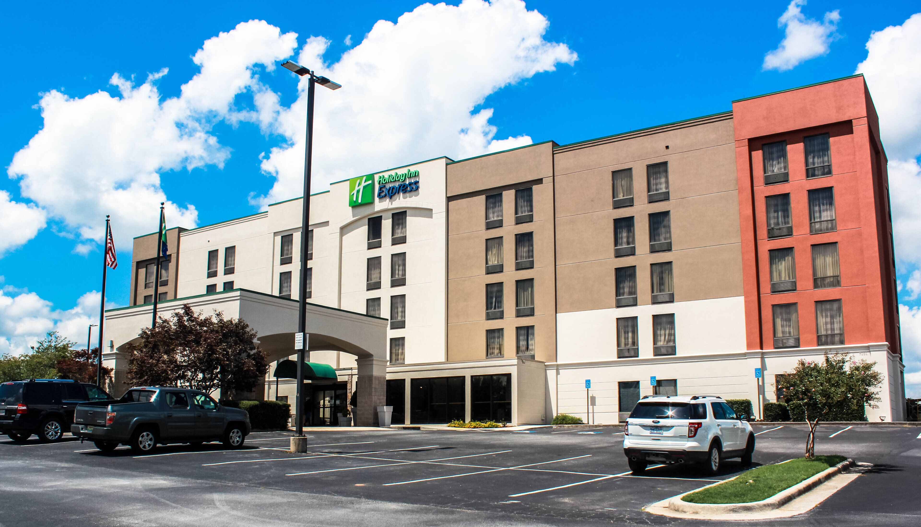 A Holiday Inn Express hotel with a parking lot and a clear blue sky.