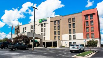 A Holiday Inn Express hotel with a parking lot and a clear blue sky.