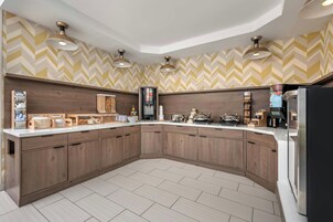 Eine moderne Küche mit gebogener Anordnung, integrierten Geräten und einer Backspüle mit Fischgrätenmuster.