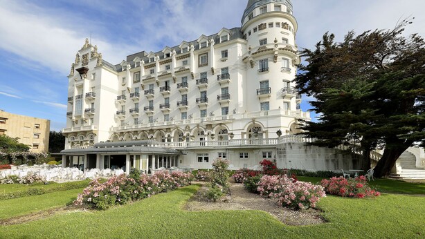 Un edificio grande e histórico con varios balcones y una cúpula central.
