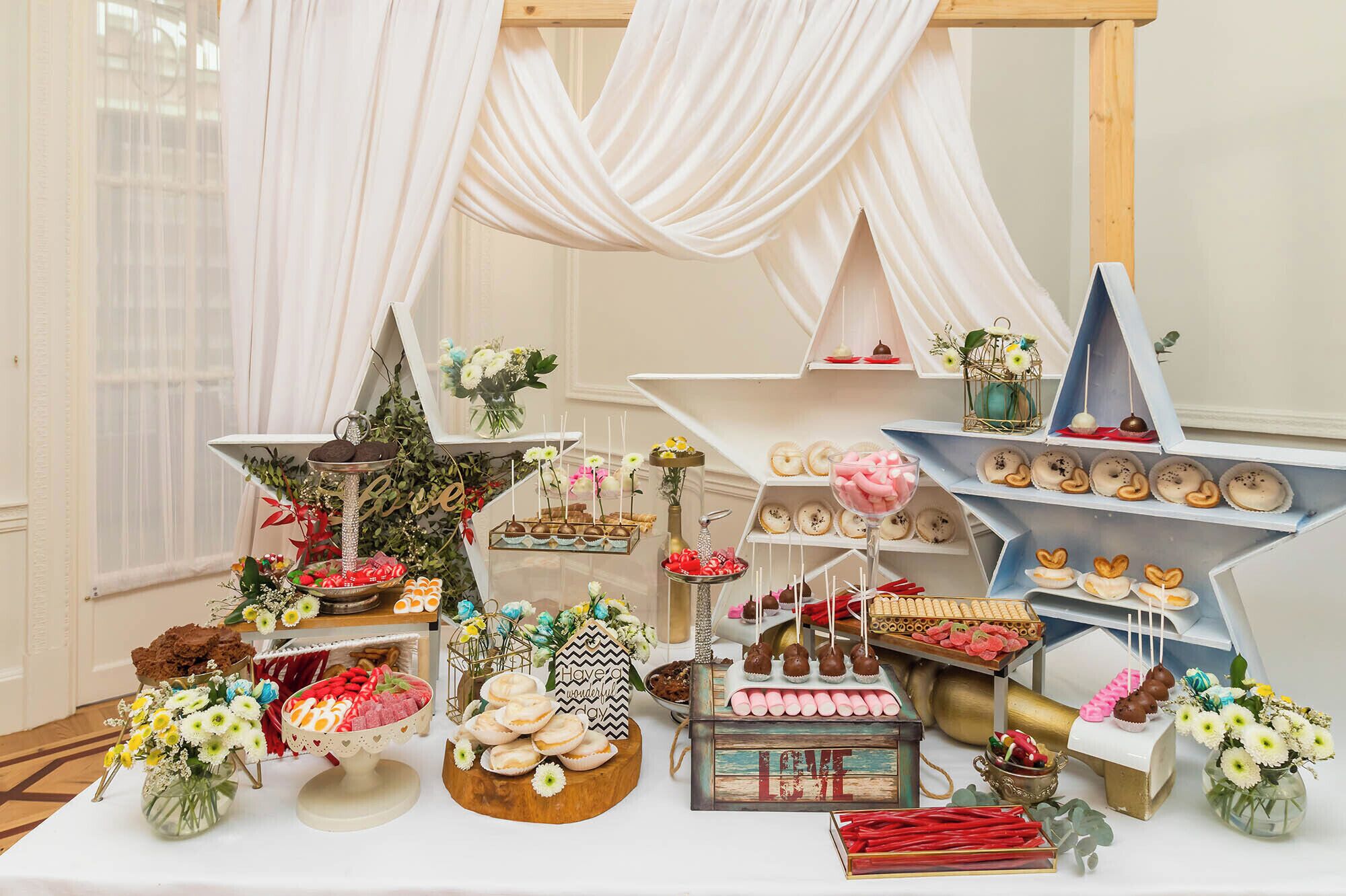 Una exhibición de postres con diversos dulces y flores.
