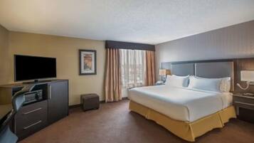 A hotel room with a bed, a television, a desk, and a chair.