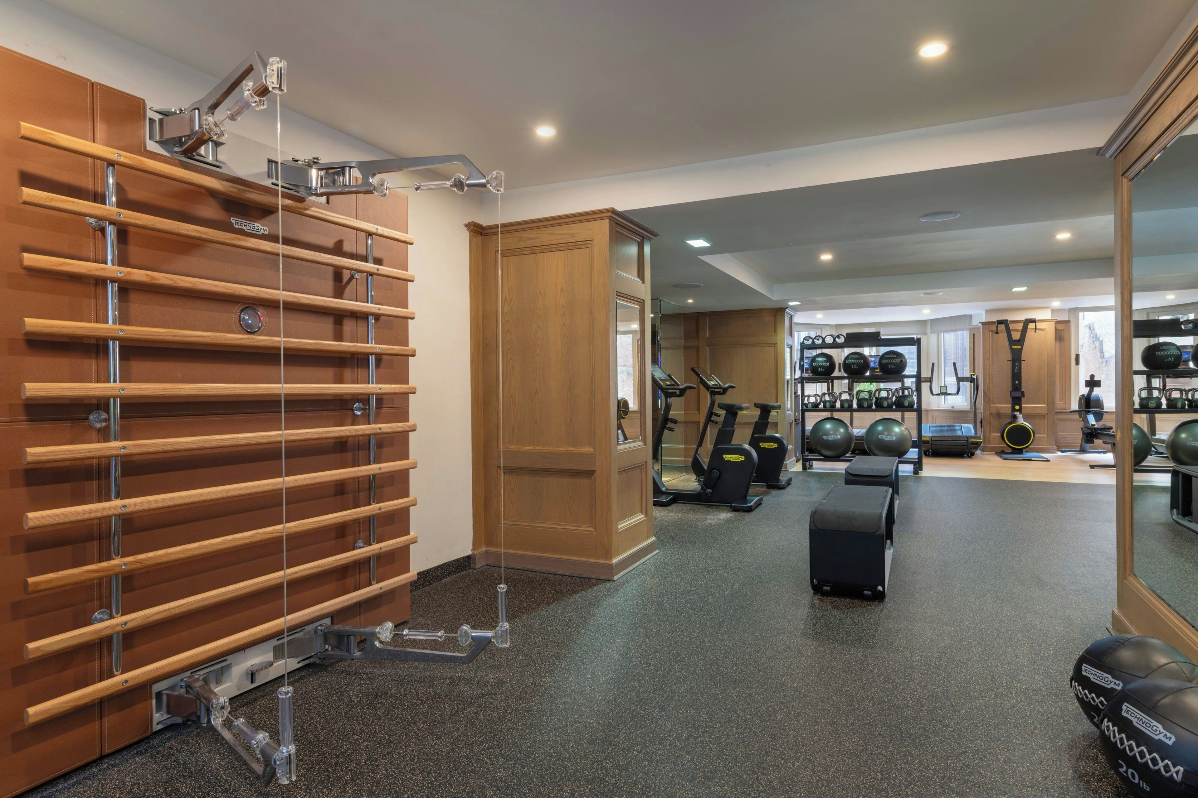 A gym with exercise equipment, a mirror, and a wooden rack.