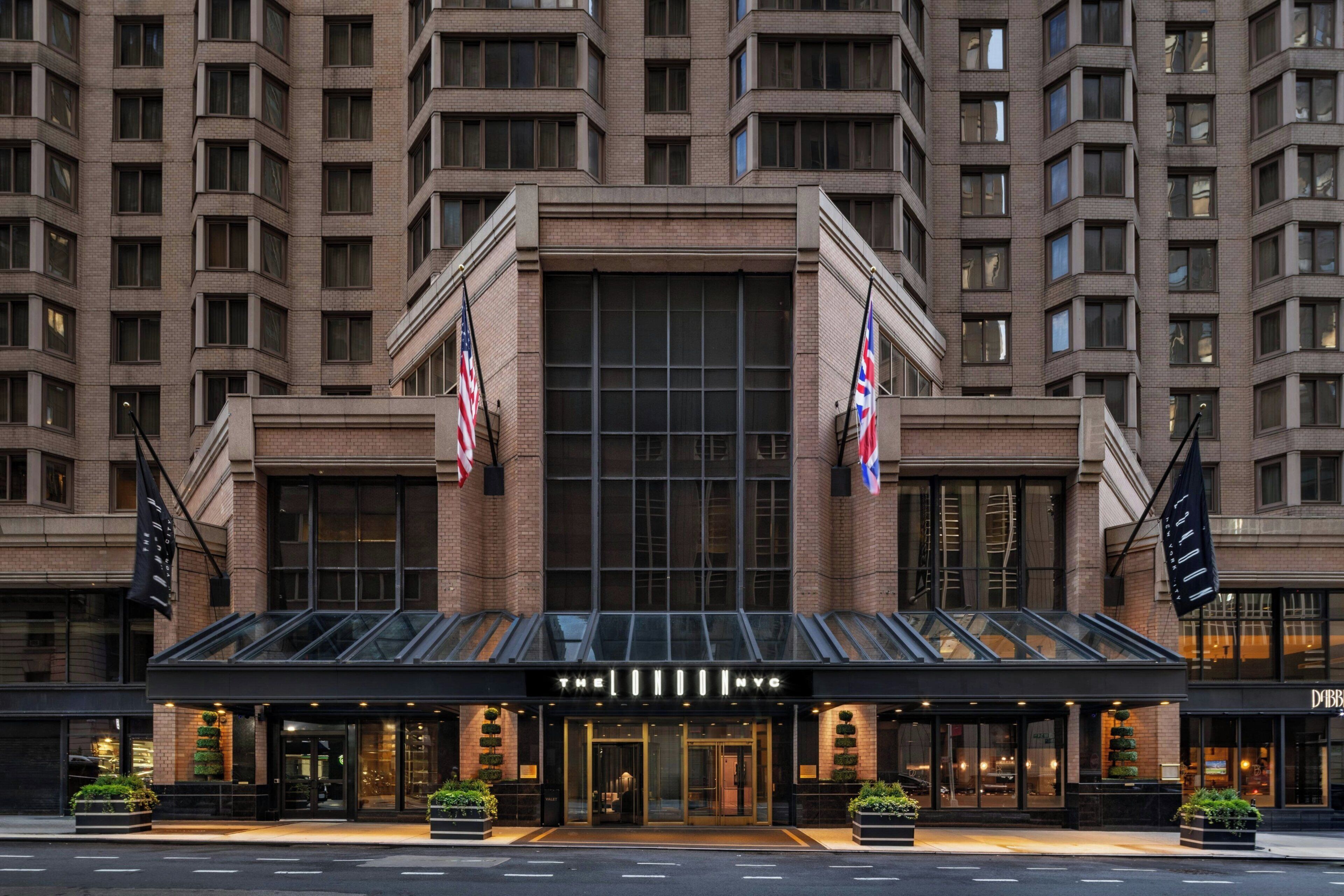 A hotel with a modern glass facade, American flags, and a prominent entrance.