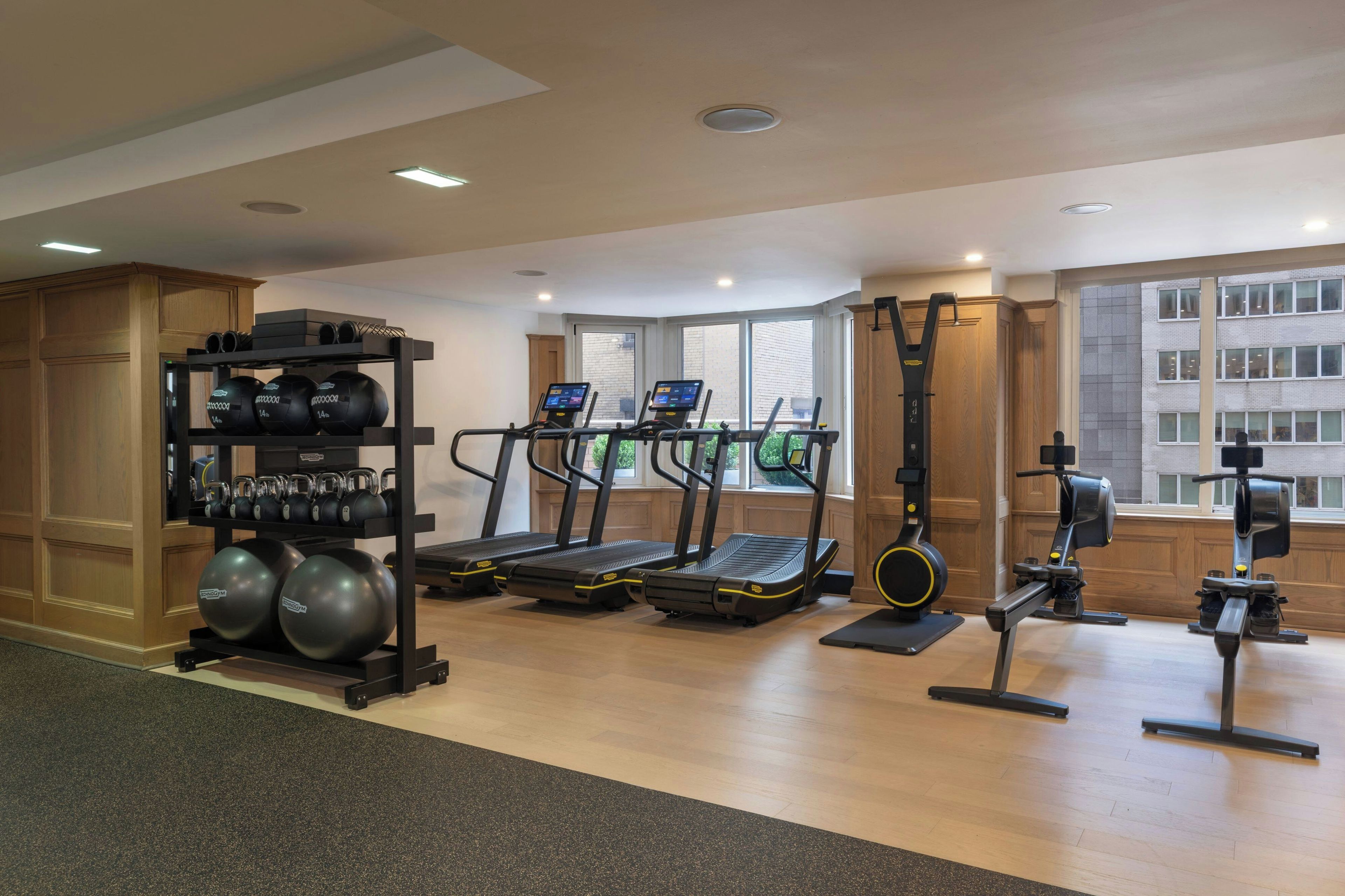 A gym with treadmills, weight machines, and a rack of dumbbells.