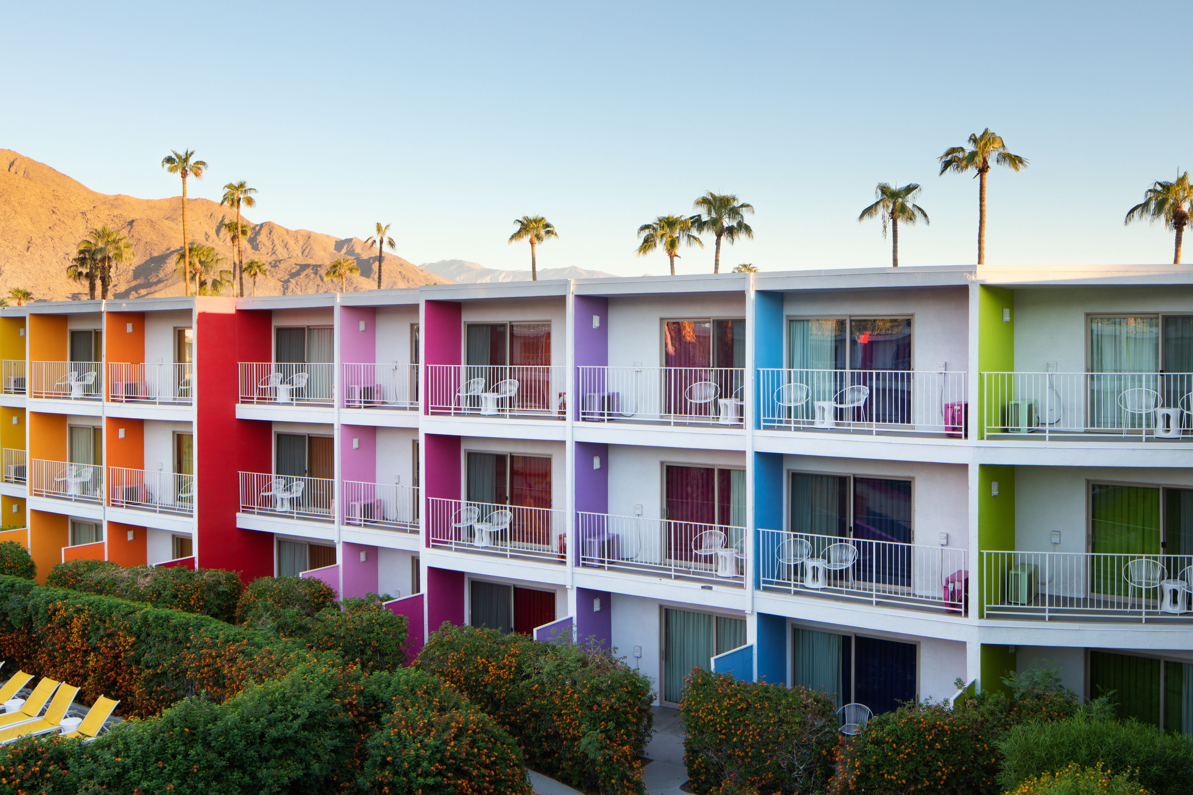 A multi-story hotel with colorful exterior walls and balconies with white railings.