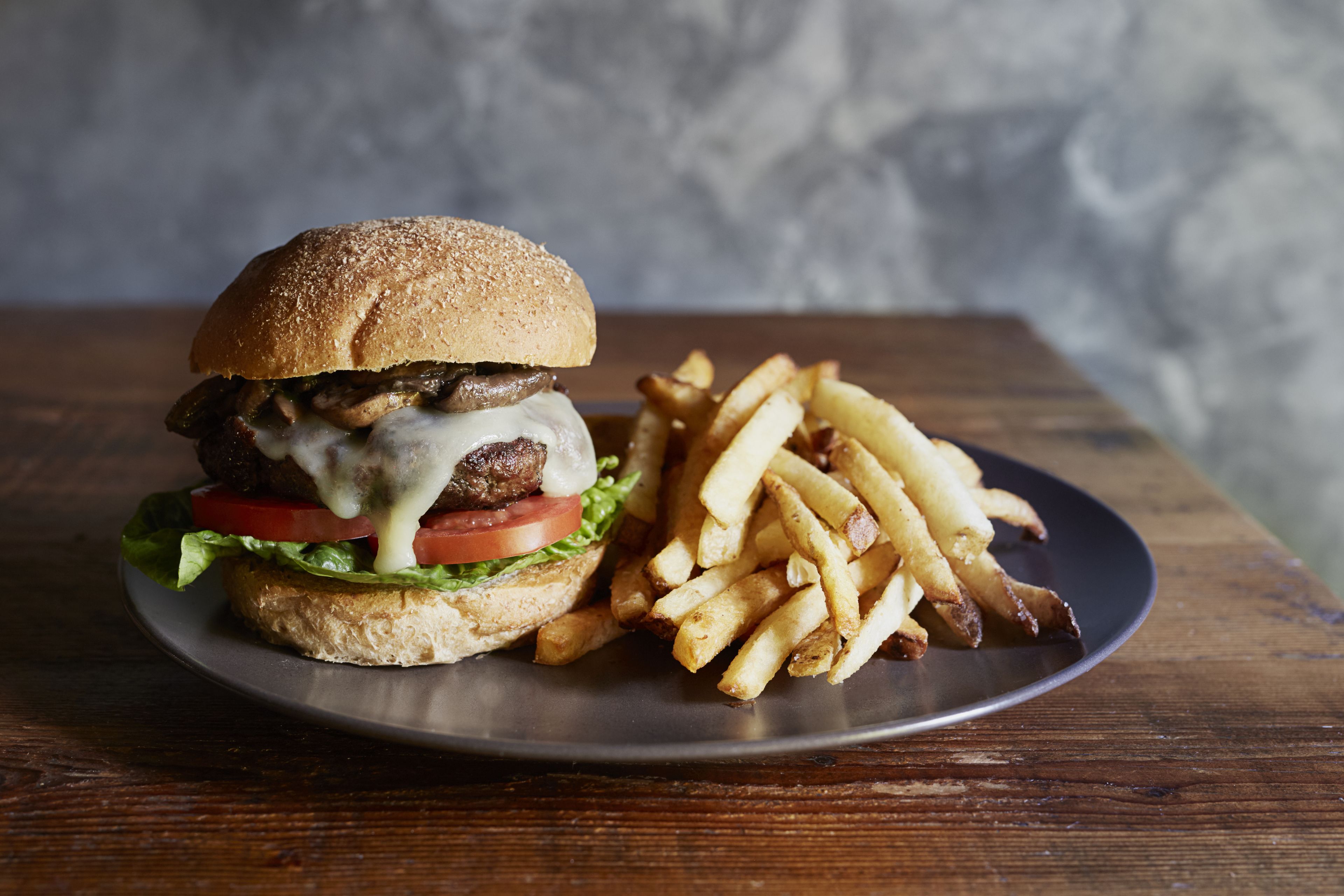 Una hamburguesa con papas fritas en un plato.