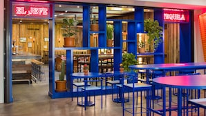 A restaurant with a blue and red color scheme, featuring outdoor seating and potted plants. - The Saguaro Palm Springs (Palm Springs)