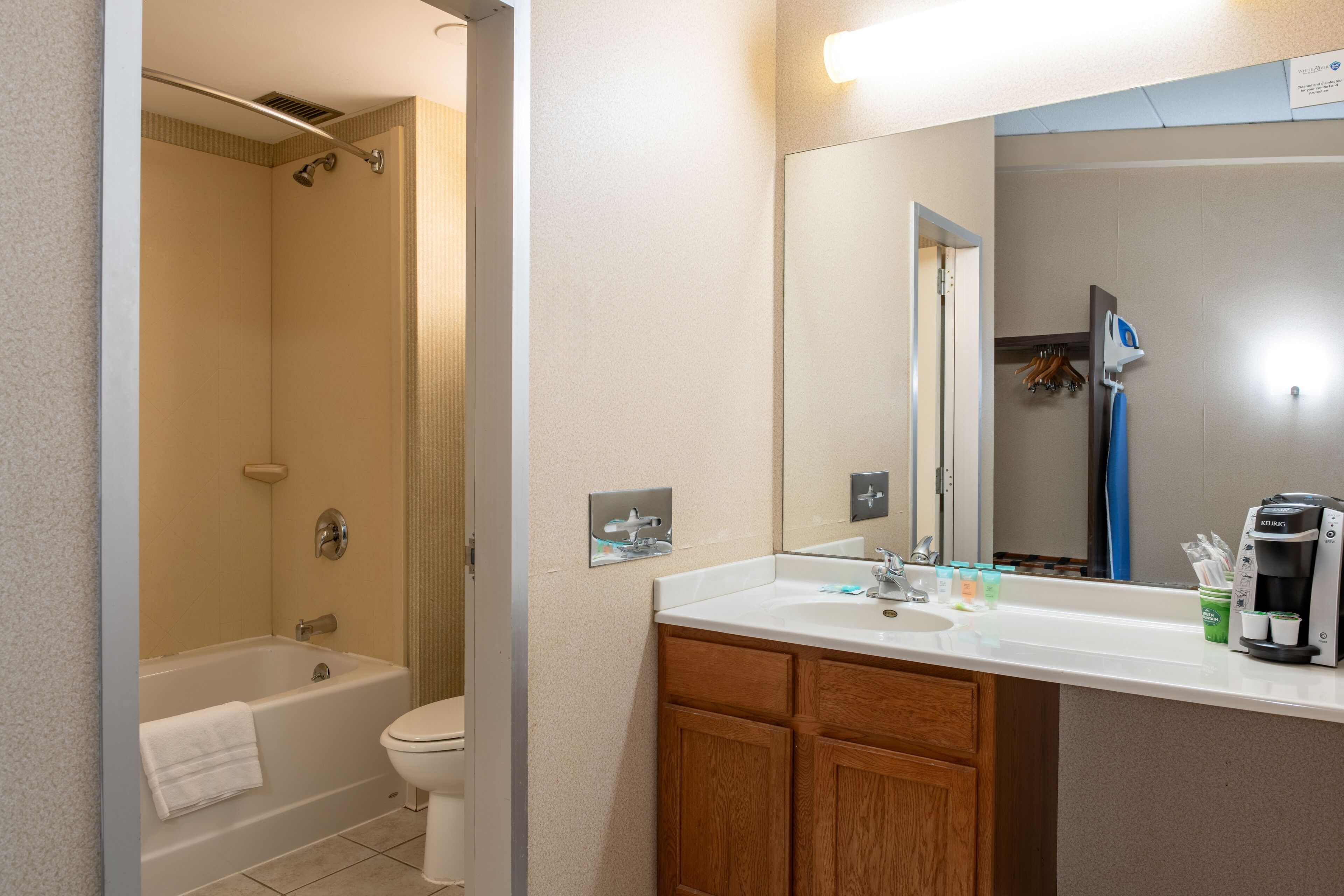 A bathroom with a bathtub, toilet, sink, and a mirror.