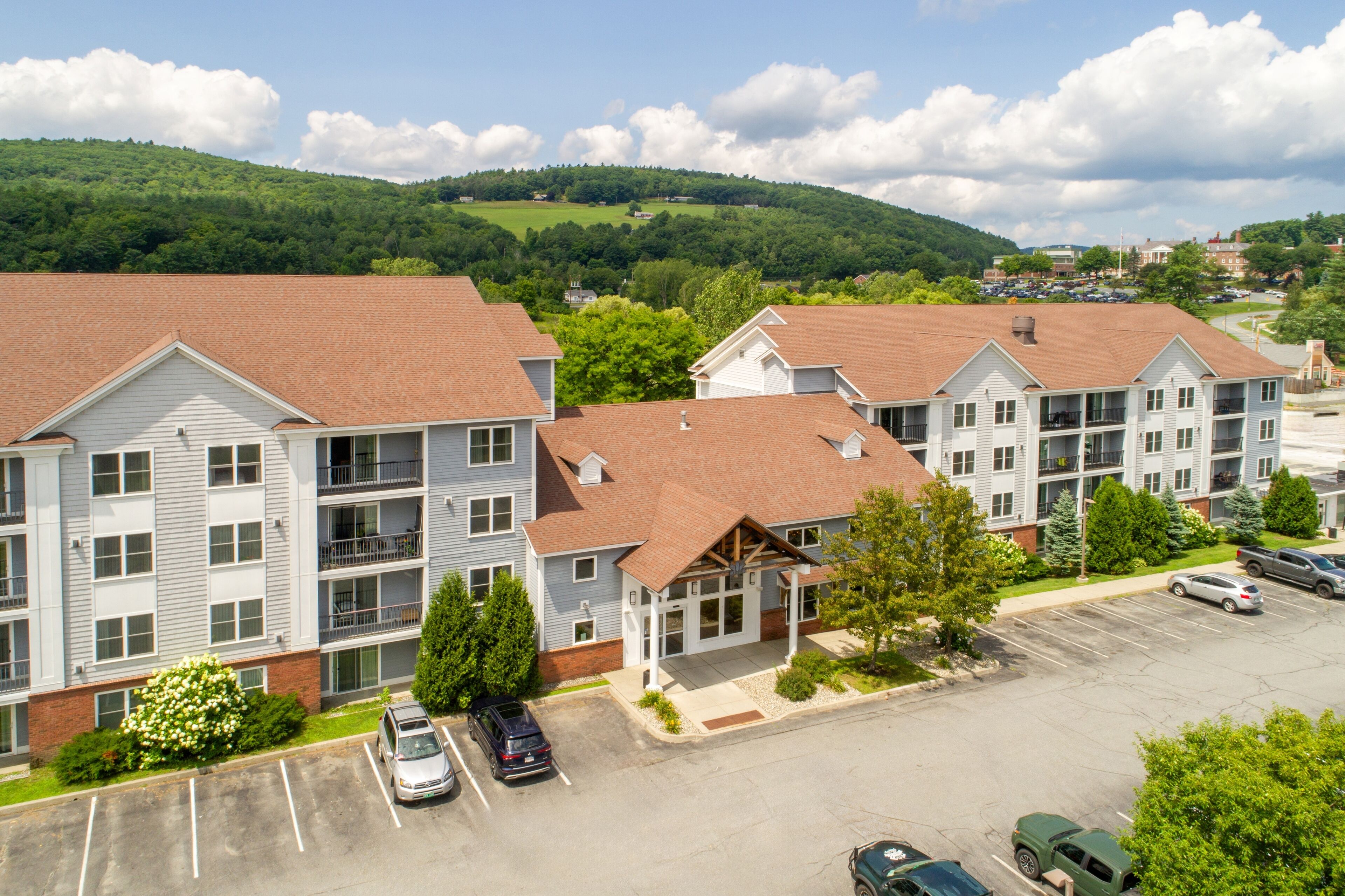 A multi-story building with a parking lot in front.