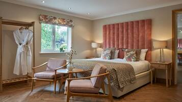 Une chambre avec un grand lit, deux tables de chevet, une chaise, un plancher en bois, une fenêtre avec vue et un porte-manteau.