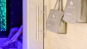 A wooden door with a handle and two bags hanging on it.