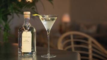 A bottle of Rick's Gin ILSA Edition and a martini glass on a table.