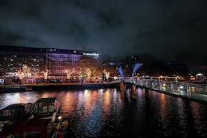 A riverside view of The Bristol Hotel with a bridge and boats.