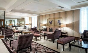 A spacious hotel lobby with a central seating area, a coffee table, and a large mirror. - Leonardo Royal Hotel Bristol (Bristol)