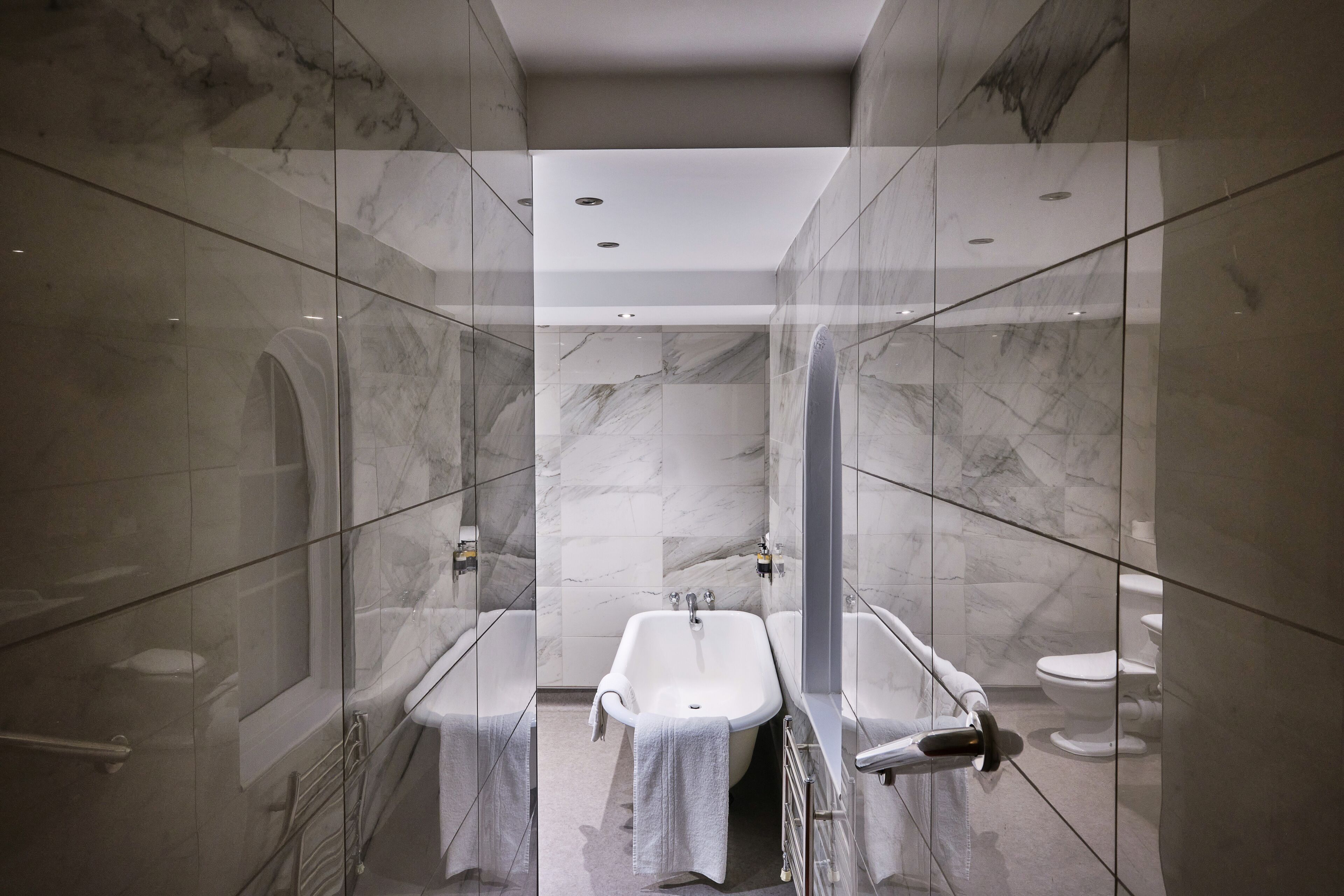 A modern bathroom with a glass-enclosed shower, a freestanding bathtub, and a separate sink.