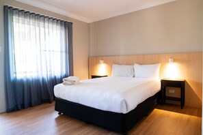 Desk, laptop workspace, iron/ironing board, bed sheets