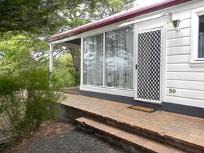 A white house with a covered porch, a sliding glass door, and a number '30' on the side.