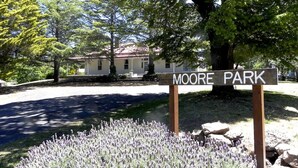 A sign for "MOORE PARK" with a house in the background. - Moore Park Inn (Armidale)