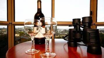 Una mesa con dos copas de vino, una botella y unos binoculares.